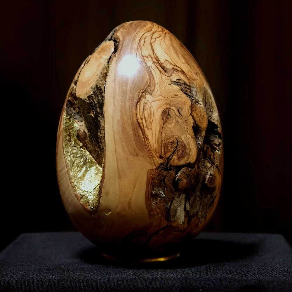 Un œuf en bois d'olivier, méticuleusement incrusté de laiton. Cet objet est bien plus qu'une simple décoration.