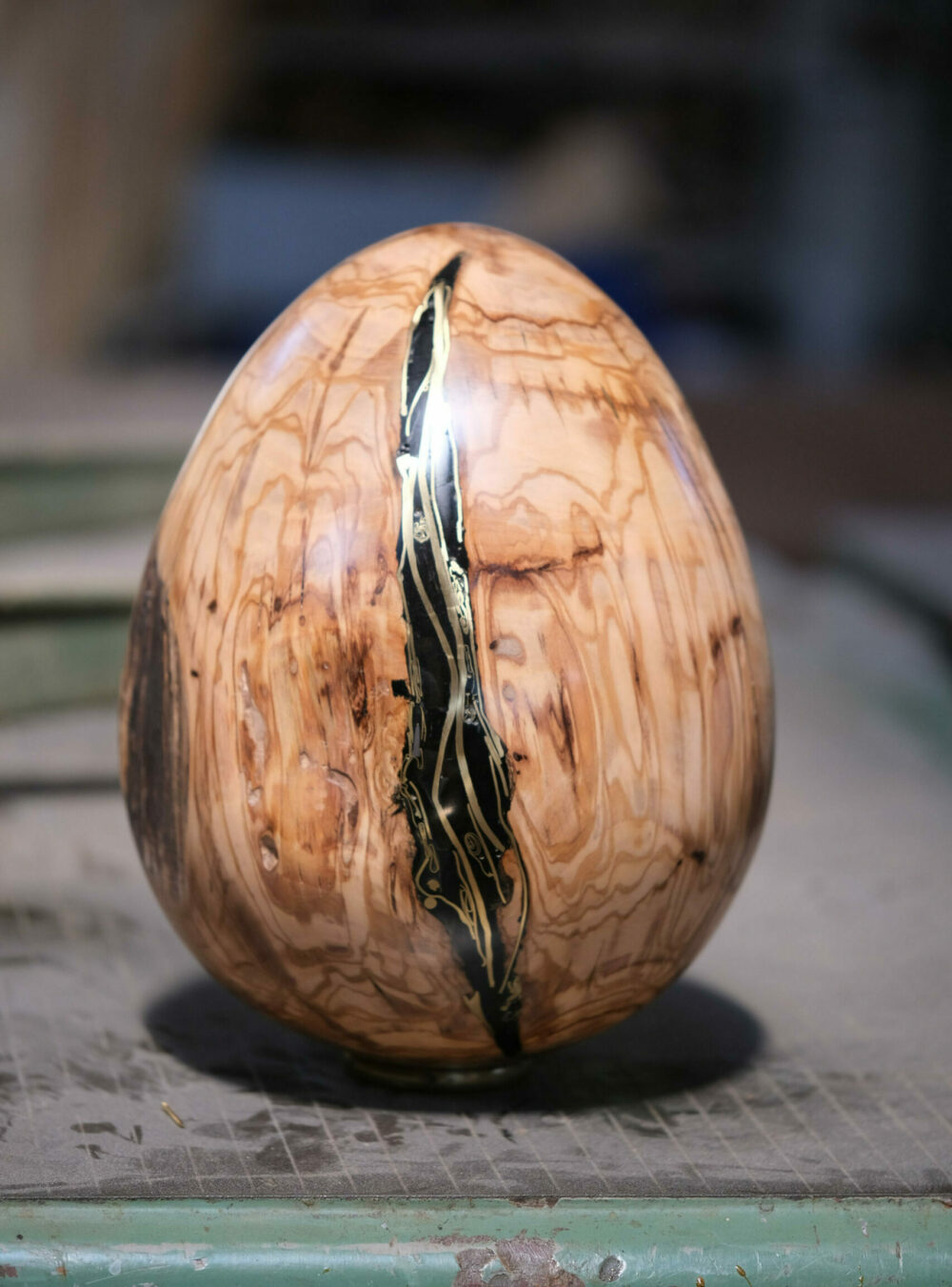 Un œuf en bois d'olivier, méticuleusement incrusté d'ébène et de laiton. Cet objet est bien plus qu'une simple décoration ; c'est une célébration de l'art du Wabi-sabi, l'esthétique japonaise qui trouve la beauté dans l'imperfection