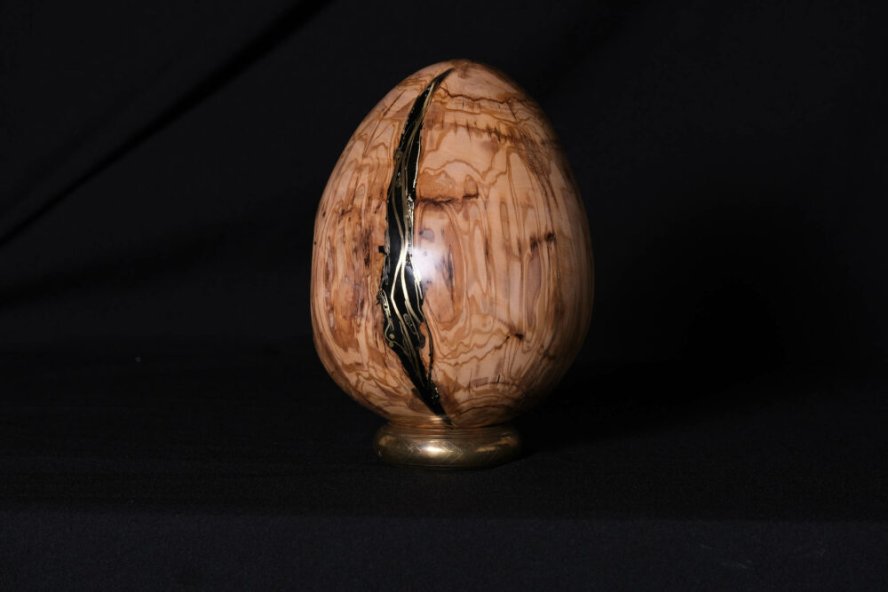 Un œuf en bois d'olivier, méticuleusement incrusté d'ébène et de laiton. Cet objet est bien plus qu'une simple décoration ; c'est une célébration de l'art du Wabi-sabi, l'esthétique japonaise qui trouve la beauté dans l'imperfection